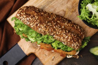 Ahşap masada şnitzel ve nefis bir sandviç.