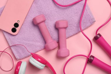 Pembe arka planda dambıl ve akıllı telefon ile düz konum