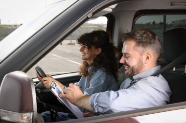 Ehliyet kursu. Otoparkta sınavı geçen mutlu öğrenci.