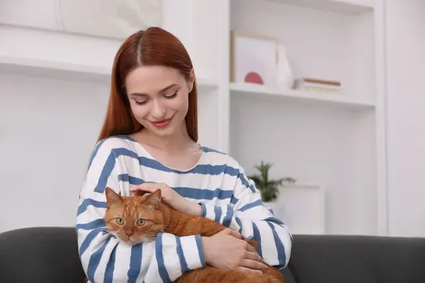 Woman with her cute cat at home, space for text