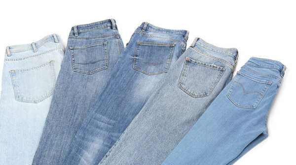 Different stylish jeans isolated on white, above view
