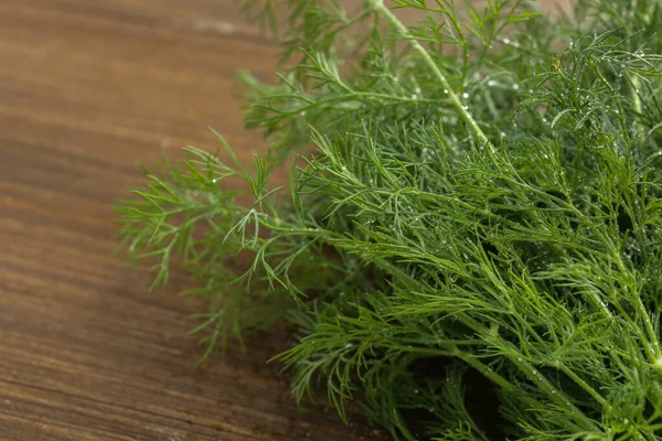 Taze yeşil dereotu ahşap masada, yakın plan.