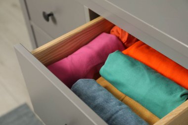 İçerideki çekmecede farklı katlanmış gömlekler. Giysileri düzenleme