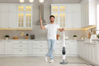 Mutfakta buhar paspası olan mutlu bir adam.