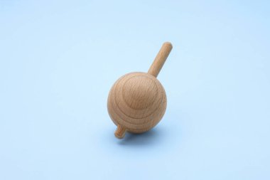 Açık mavi arkaplanda dönen bir ahşap kaplama. Oyuncak girdabı