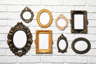 Beyaz tuğla duvarda asılı boş vintage çerçeveler. Tasarım için model