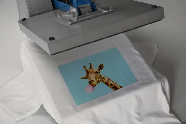 Custom t-shirt. Using heat press to print image of giraffe blowing bubble gum