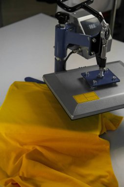 Yazıcı logosu. Beyaz masadaki tişörtlü ısı baskısı