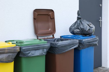 Dışarıdaki çöp ve geri dönüşüm kutularıyla dolu plastik torba. Atık sıralama