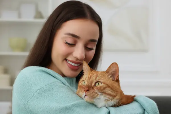 Beautiful woman with cute cat at home