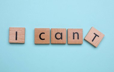 Motivasyon konsepti. I Can 'den I Can' e geçiş cümlesini, açık mavi zemin üzerinde T harfiyle ahşap kareyi kaldırarak yapabilirim.