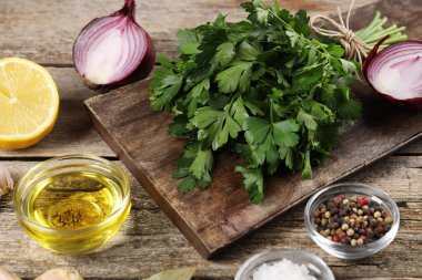 Taze maydanoz, baharat ve diğer ürünler ahşap masada, yakın plan.