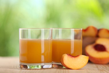 Lezzetli şeftali suyu ve ahşap masada taze meyveler, yakın plan.