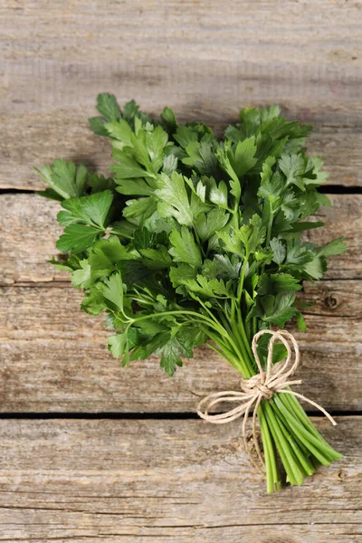 Bunch of fresh green parsley leaves on wooden table, top view