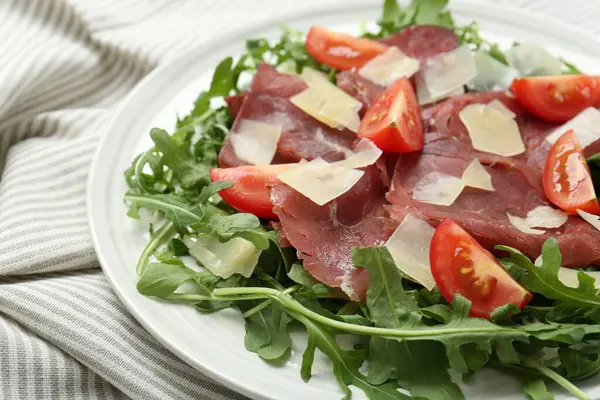 Masa örtüsünde parmesan peynirli nefis bresaola salatası, yakın çekim.