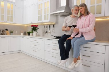 Mutfakta şarap kadehleri olan mutlu son sınıf çifti. Metin için boşluk