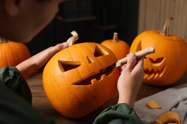 Ahşap masada balkabağı oyan kadın, yakın plan.