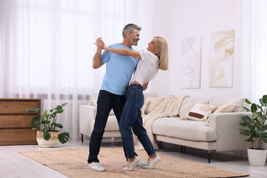 Mutlu, sevgi dolu bir çift evde dans ediyor, mesaj için yer var. Romantik randevu