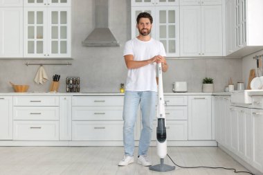 Mutfakta buhar paspası olan mutlu bir adam.