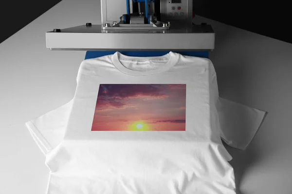 Custom t-shirt. Using heat press to print image of beautiful sunset sky