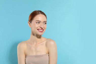 Açık mavi arka planda güzel bir genç kadın, metin için boşluk