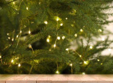 Güzel dekore edilmiş Noel ağacının yanındaki ahşap masa. Tasarım için boşluk