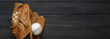 Deri beyzbol eldiveni ve top siyah ahşap masada, üst manzara. Metin için alanı olan pankart tasarımı