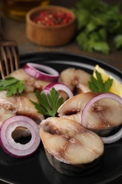 Lezzetli tuzlu uskumru, soğan halkaları ve maydanoz dilimleri.