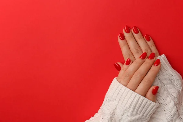 Woman with gel polish on nails against red background, top view. Space for text