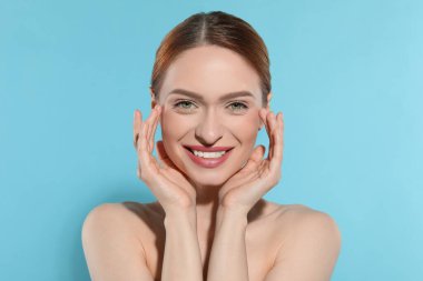 Açık mavi arka planda güzel genç kadın