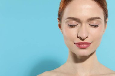 Açık mavi arka planda güzel bir genç kadın. Metin için boşluk