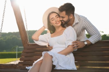 Romantik bir randevu. Güzel bir çift dışarıda salıncakta birlikte vakit geçiriyor.