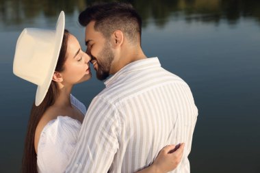 Romantik bir randevu. Güzel çift göl kenarında öpüşüyor.