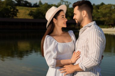 Romantik bir randevu. Güzel bir çift göl kenarında vakit geçiriyor.