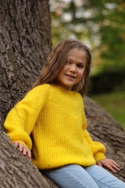Sonbahar parkında, ağacın yanında güzel bir kızın portresi.