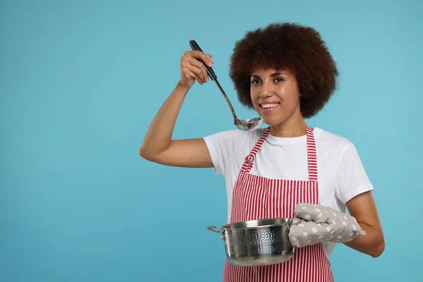 Glad Ung Kvinna Förkläde Håller Slev Och Matlagning Potten Ljusblå — Stockfoto
