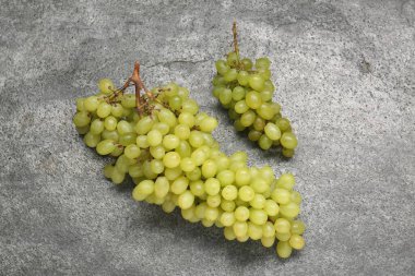 Gri desenli masada taze yeşil üzümler, üst manzara.