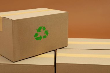 Cardboard box with recycle sign stamp on brown background clipart