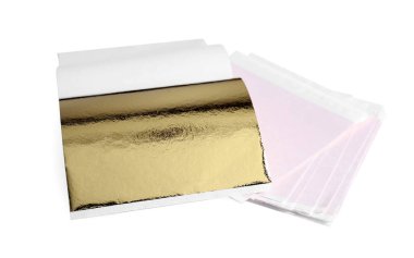 Beyaz ahşap masanın üzerinde bir sürü yenilebilir altın yaprak var.