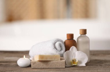 Spa ürünleri ile kompozisyon, ahşap masa üzerindeki güzel çiçek ve mum bulanık arkaplan, metin için boşluk