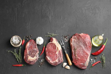 Çiğ et parçaları, ürünler ve baharatlar siyah desenli masa, düz yatak. Metin için boşluk