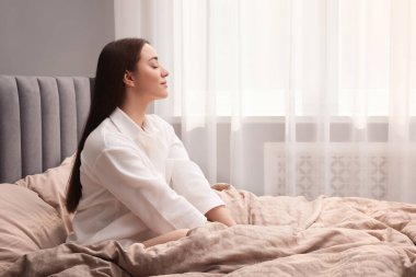 Evde yatakta oturan güzel bir kadın, mesaj atmak için yer var. Tembel sabah