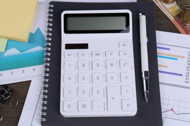 Hesap makinesi, kağıtlar, kalem, defter ahşap masanın üstünde. Emeklilik planı