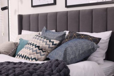 Odasında yumuşak yastıklar ve battaniyeler olan büyük, rahat bir yatak. Ev tekstili