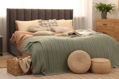 Yumuşak yastıkları ve odada battaniyesi olan büyük, rahat bir yatak. Ev tekstili