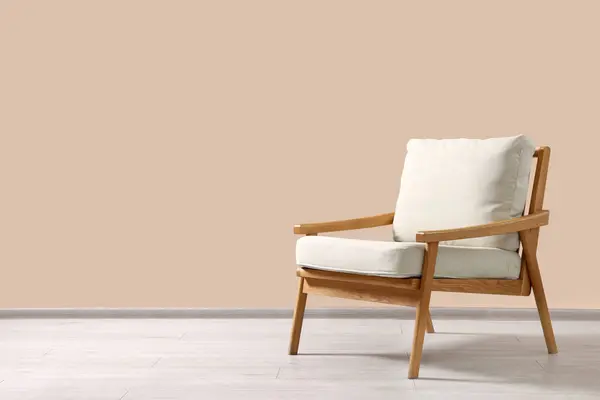 Stylish armchair near beige wall indoors, space for text