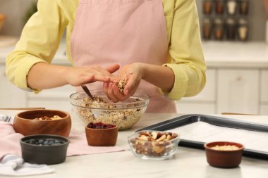 Mutfaktaki masada granola yapan kadın, yakın plan.