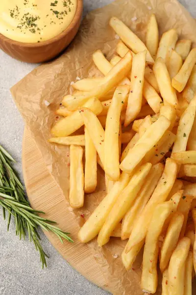 stock image Delicious french fries served with sauce on grey textured table, flat lay