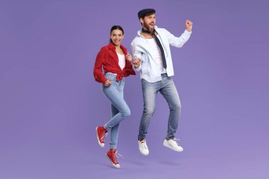 Mutlu çift menekşe arka planda dans ediyor.