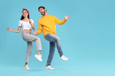 Açık mavi arka planda dans eden mutlu çift, mesaj için alan